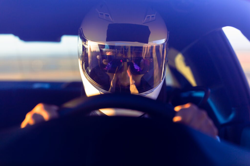 A helmeted racecar driver figuratively demonstrates the power of a sales tracking dashboard to control business performance.