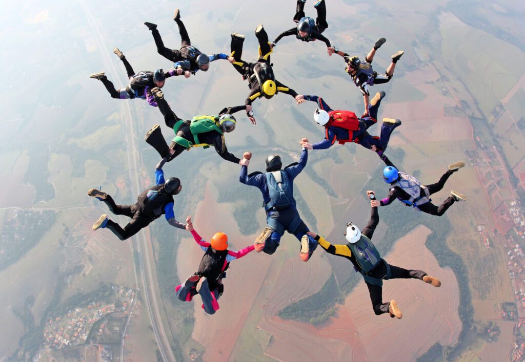 An image of a group of skydivers holding onto each other in a geometric formation representing the connecting pieces of incentive compensation managment.