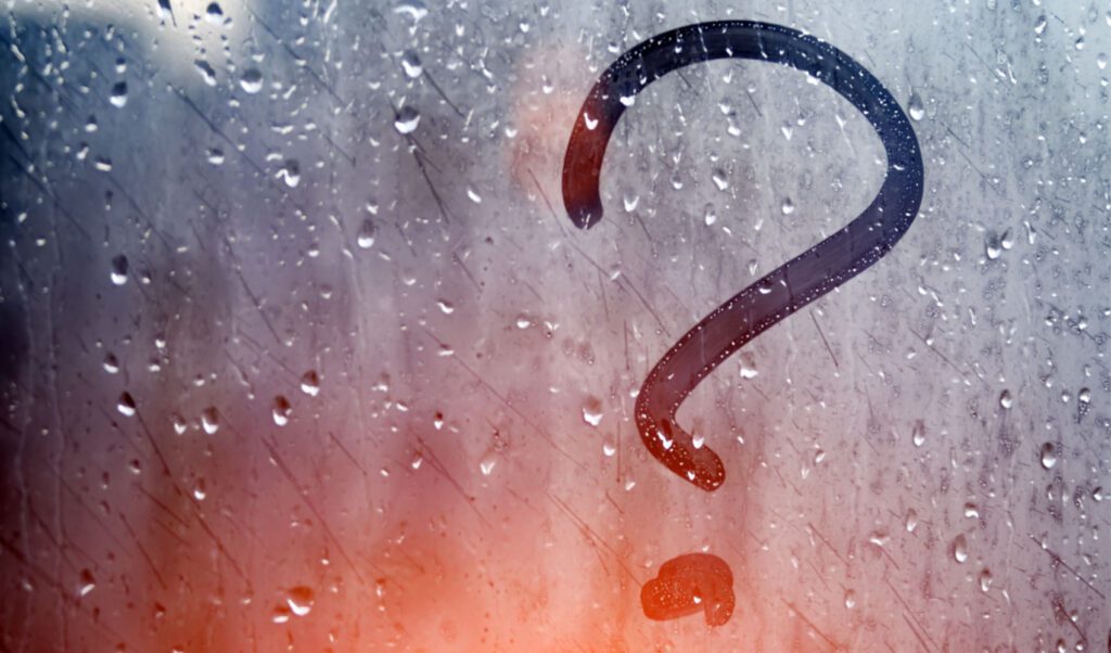 Picture of a wet and foggy window with a question mark etched in the fog representing questions about sales compensation