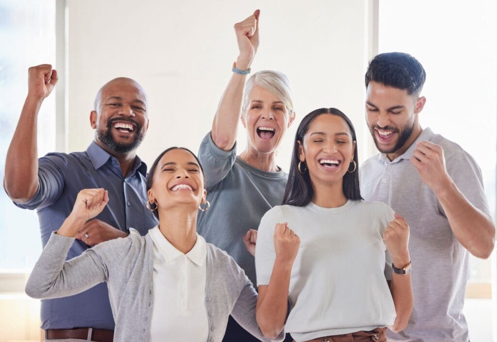 Team of employees express excitement over the news of meeting their bonus pool goals